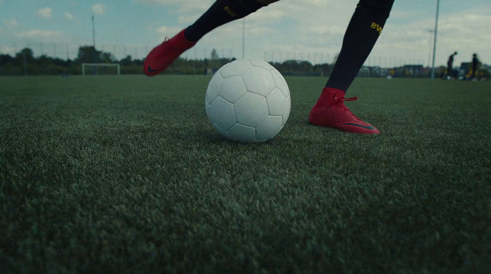 a person kicking a soccer ball on a field