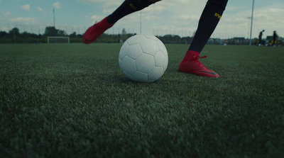 a person kicking a soccer ball on a field