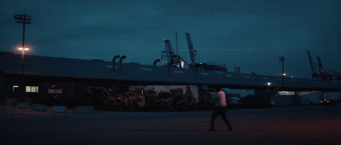 a man walking in front of a building at night