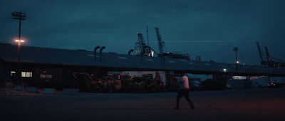 a man walking in front of a building at night