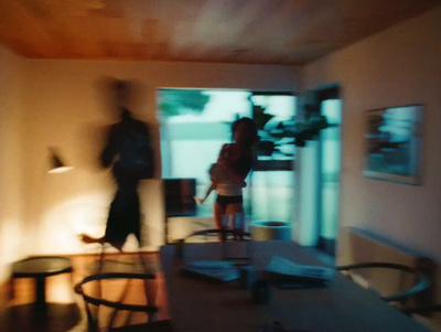 a blurry photo of a couple walking through a living room