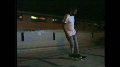 a man riding a skateboard down a street at night