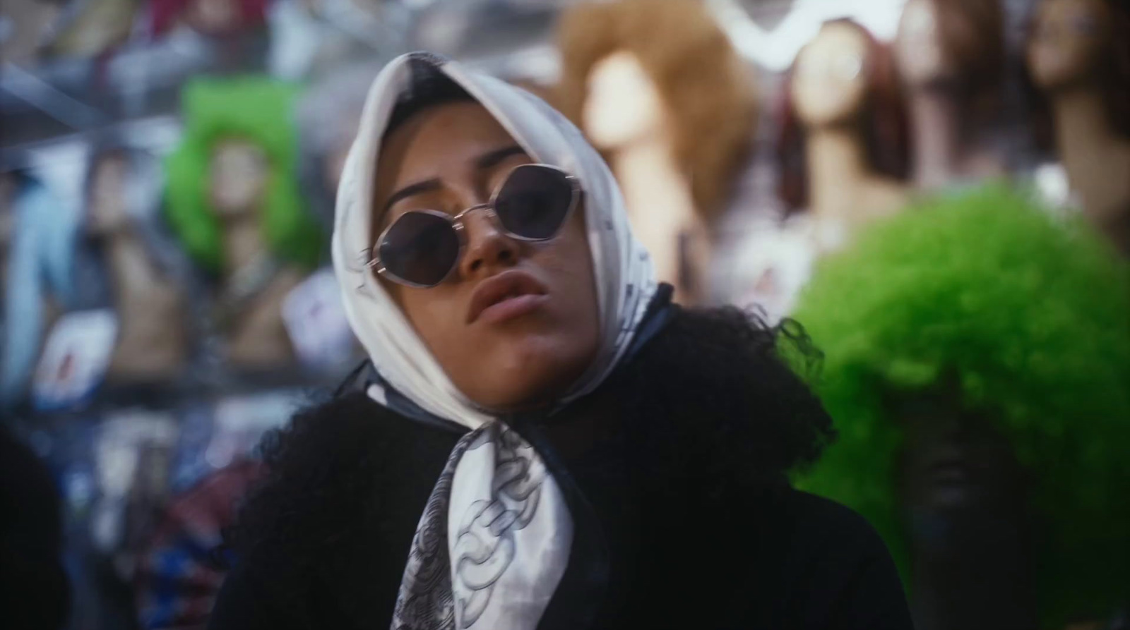 a woman wearing sunglasses and a scarf around her neck