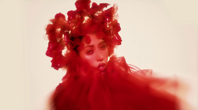 a woman in a red dress with flowers on her head