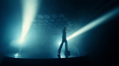 a person standing in front of a stage with lights