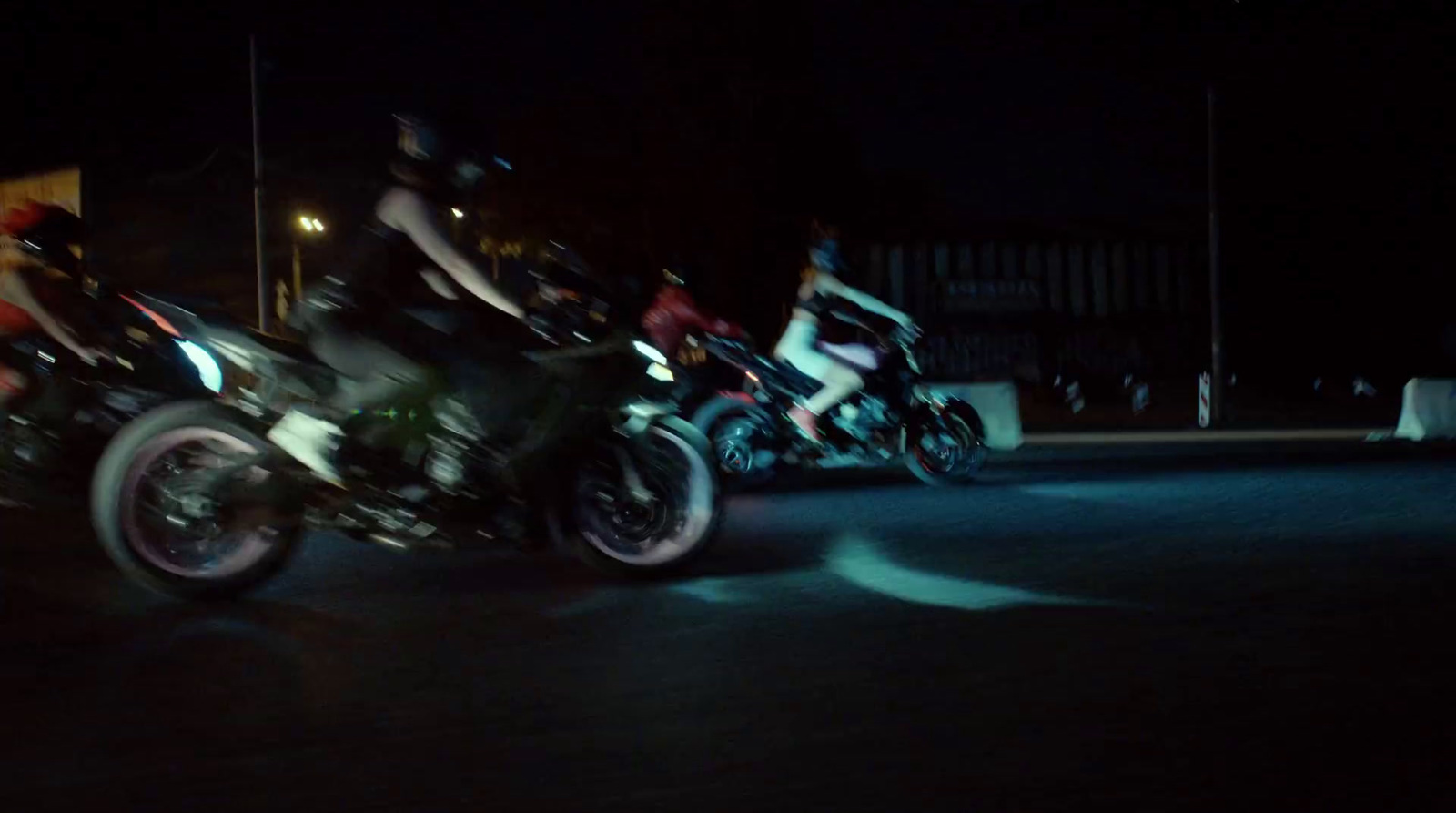 a group of people riding motorcycles at night