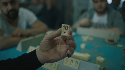 a person holding up a dice with the number ten on it