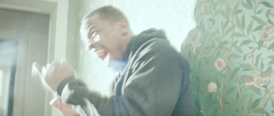 a man in a hoodie is screaming in front of a window