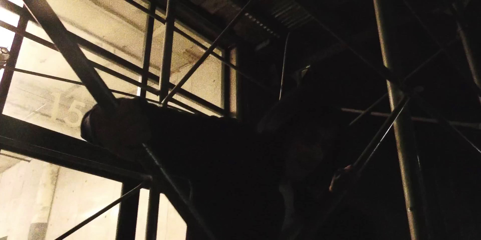 a person climbing up a ladder in the dark