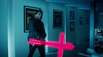 a man holding a neon pink object in a hallway