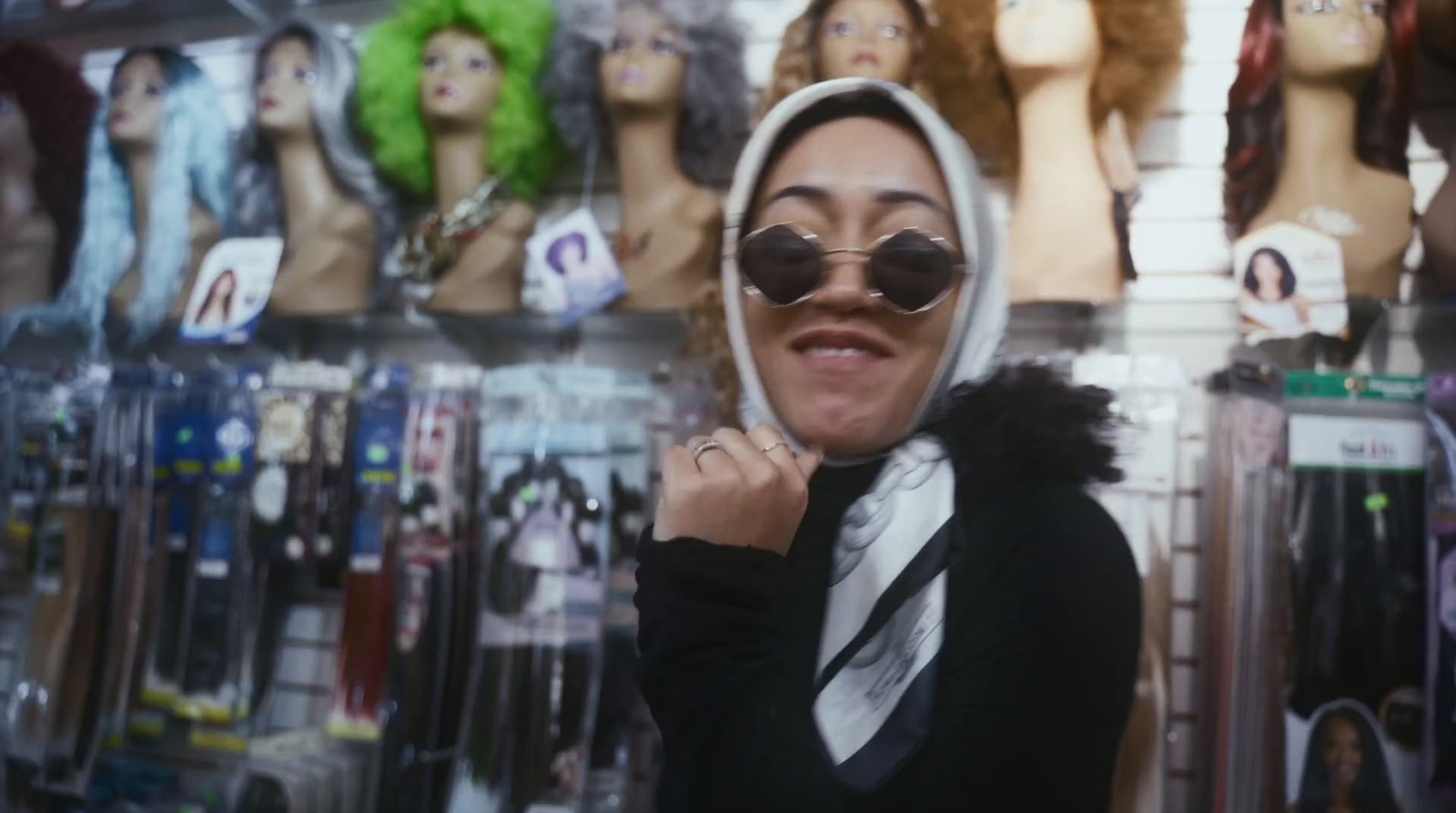 a woman wearing sunglasses and a hoodie in a store