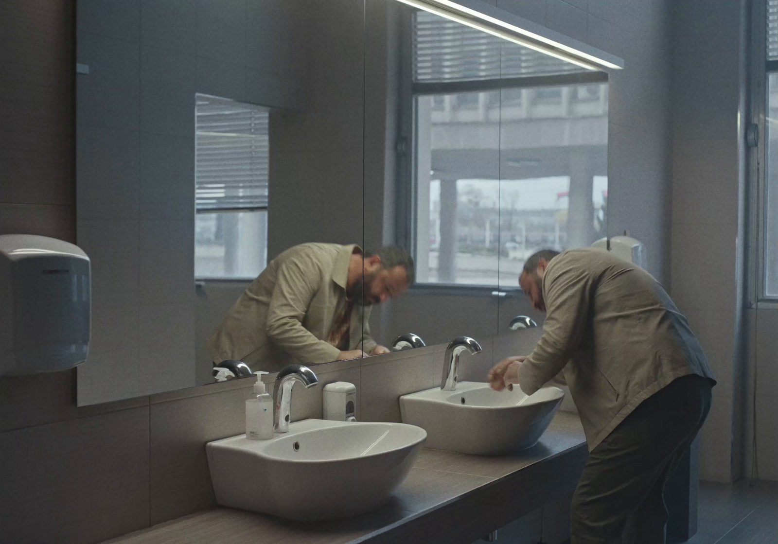 a couple of men standing in front of a bathroom sink