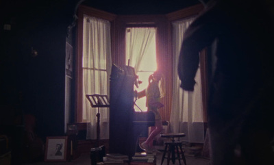 a woman standing in front of a window in a dark room