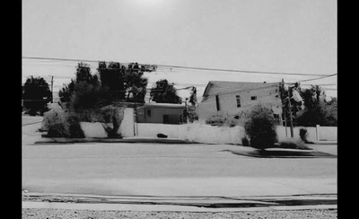 a black and white photo of a house and trees