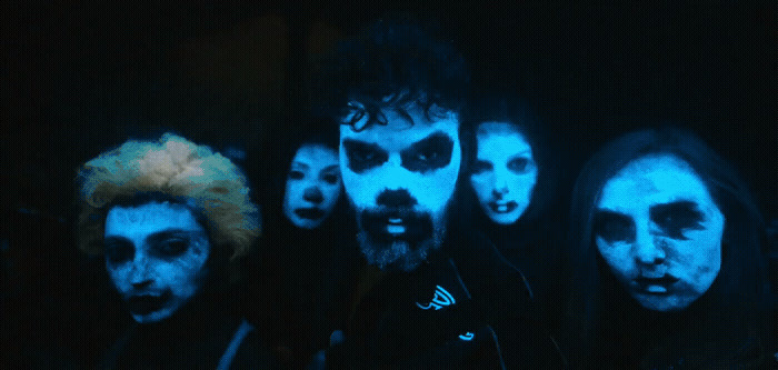 a group of people with painted faces in the dark