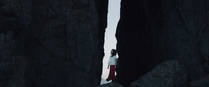 a person standing in between two large rocks