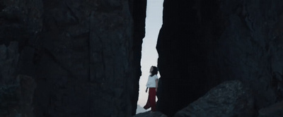 a person standing in between two large rocks