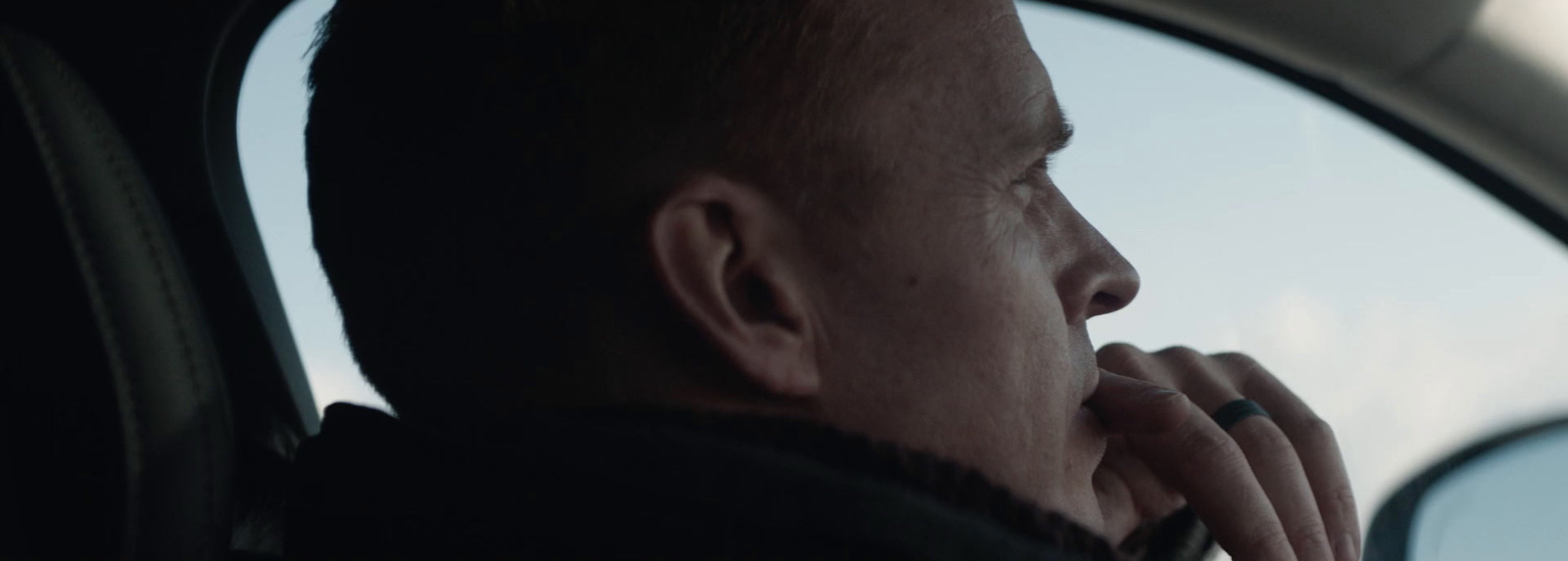 a man sitting in a car looking out the window