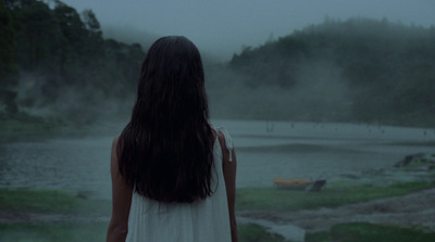 a woman standing in front of a body of water