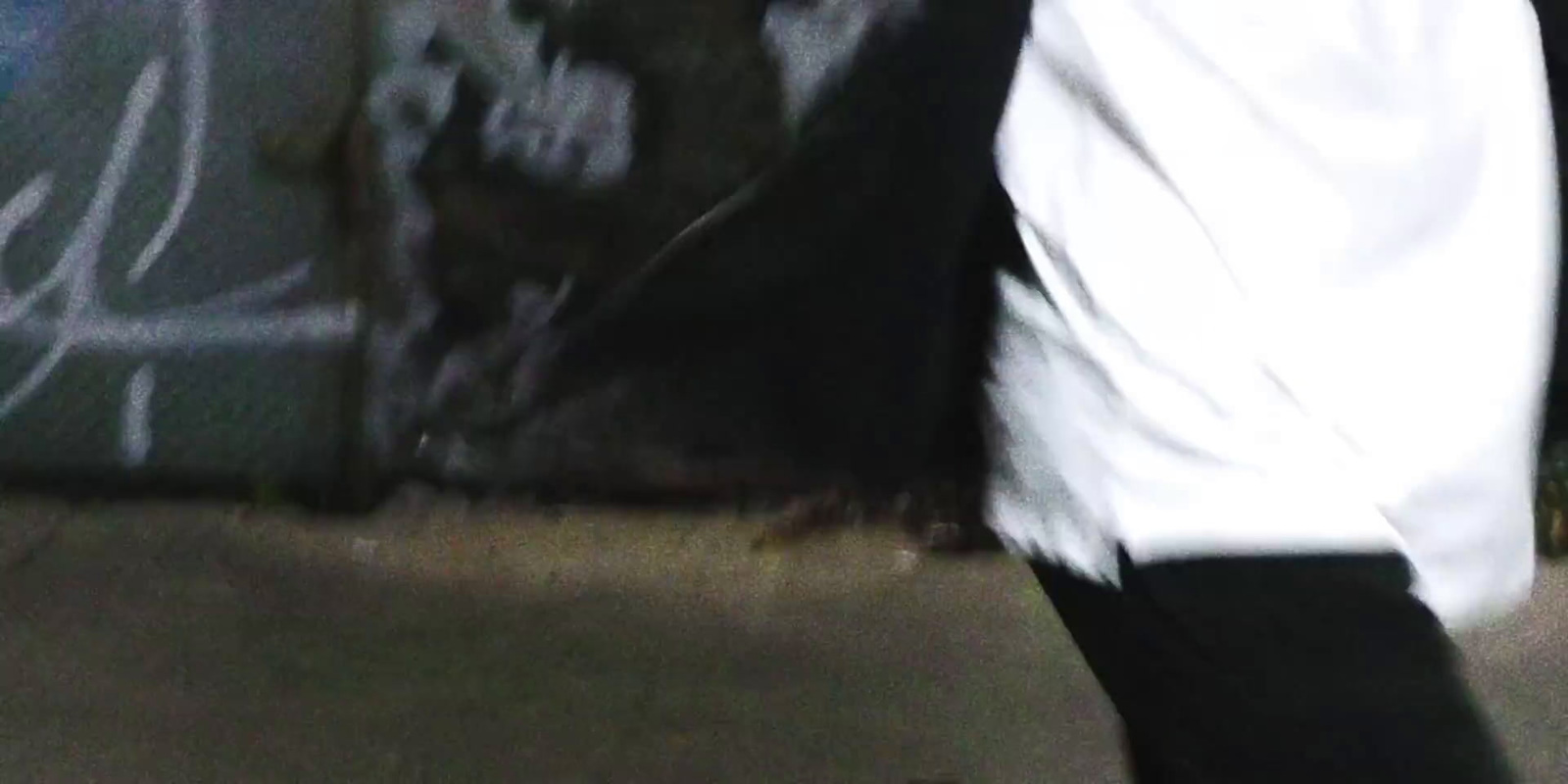 a blurry image of a person walking by a wall