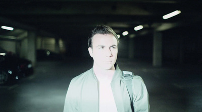 a man standing in a parking garage next to a car