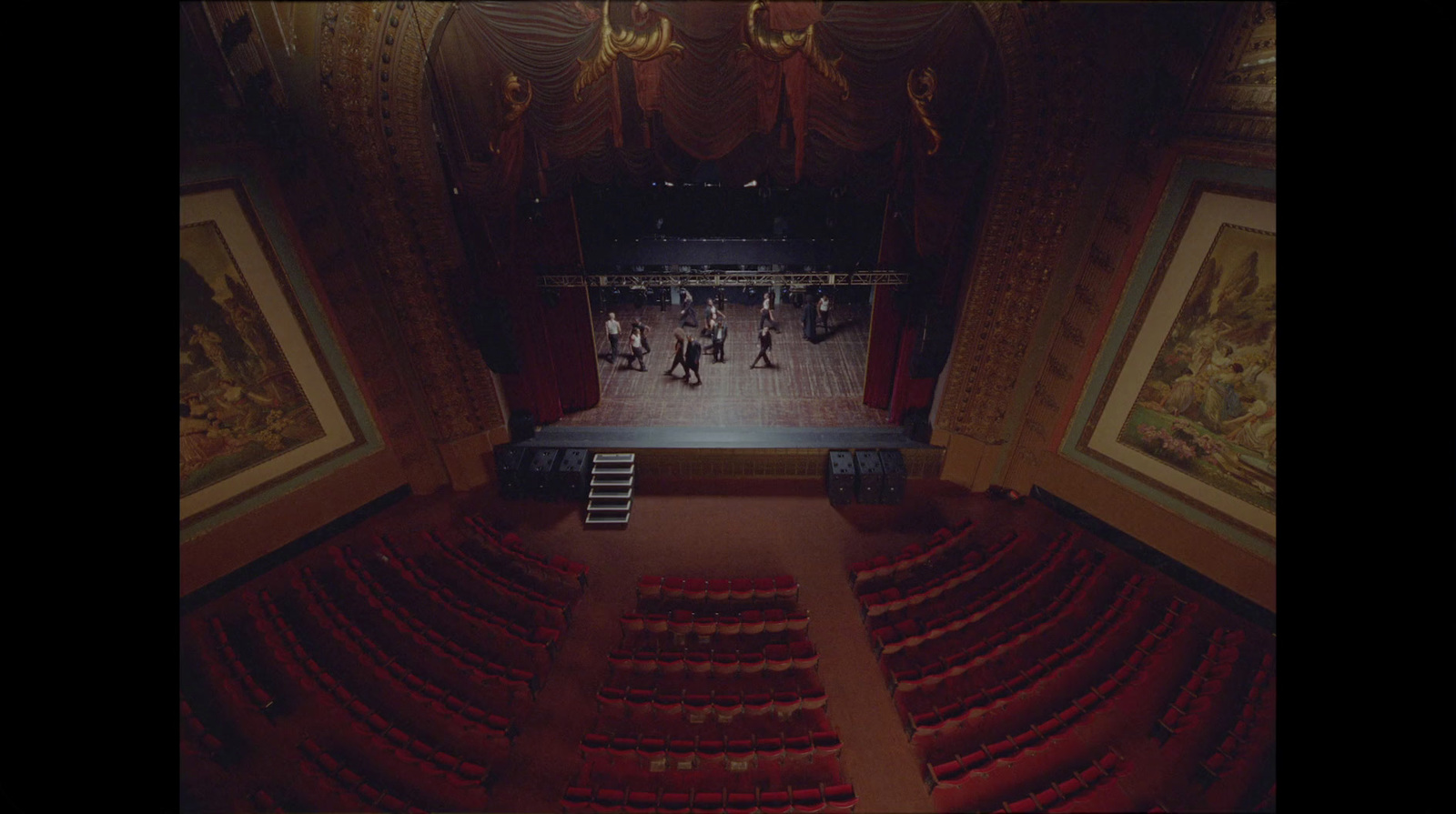 an empty theater with a ladder leading up to the stage