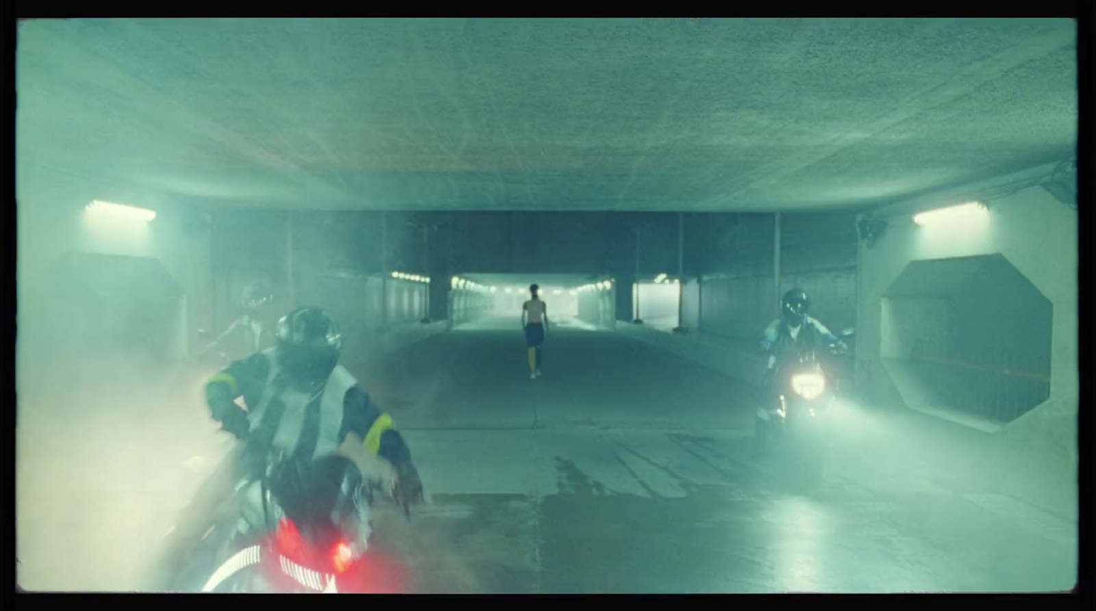 a group of people riding motorcycles through a tunnel