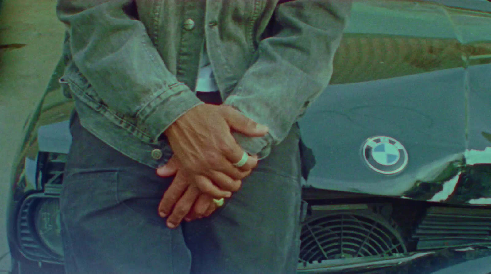 a man holding the hand of a woman in front of a bmw car