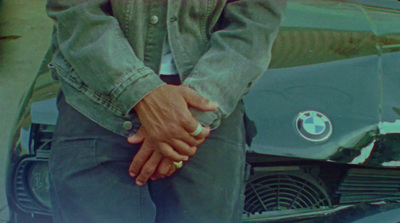 a man holding the hand of a woman in front of a bmw car