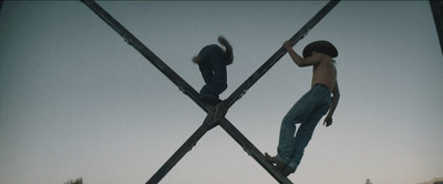 a couple of men standing on top of metal poles