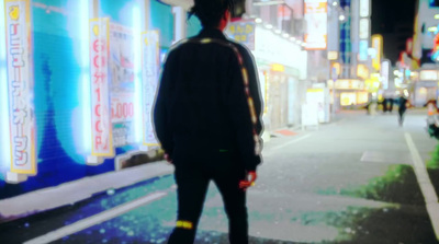 a man standing on the side of a street at night