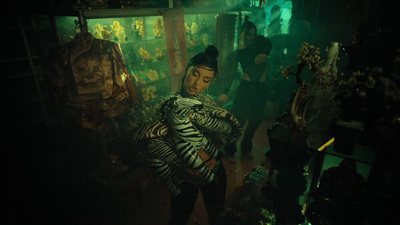 a woman standing in a room with a zebra print coat