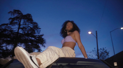 a woman sitting on the hood of a car