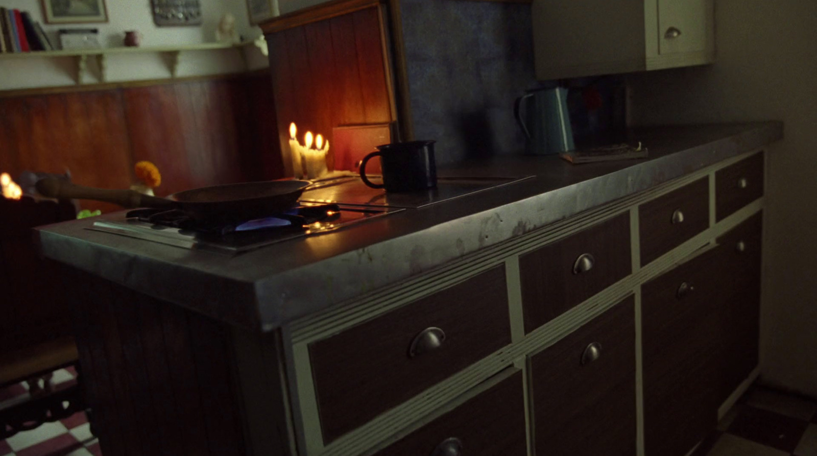 a kitchen counter with a lit candle on top of it