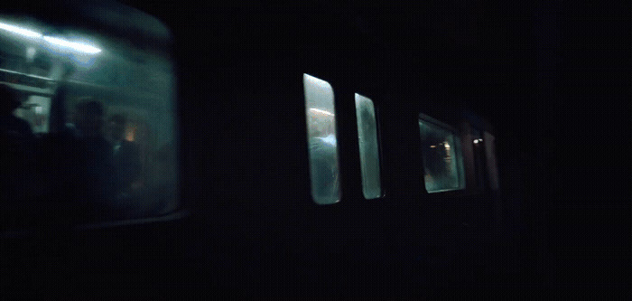 a dark photo of a train with people inside