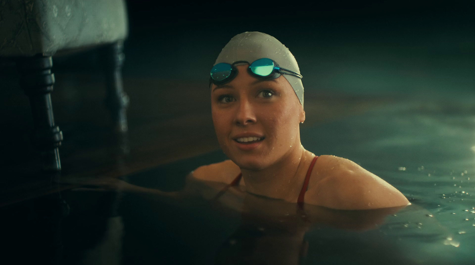 a woman swimming in a pool with goggles on