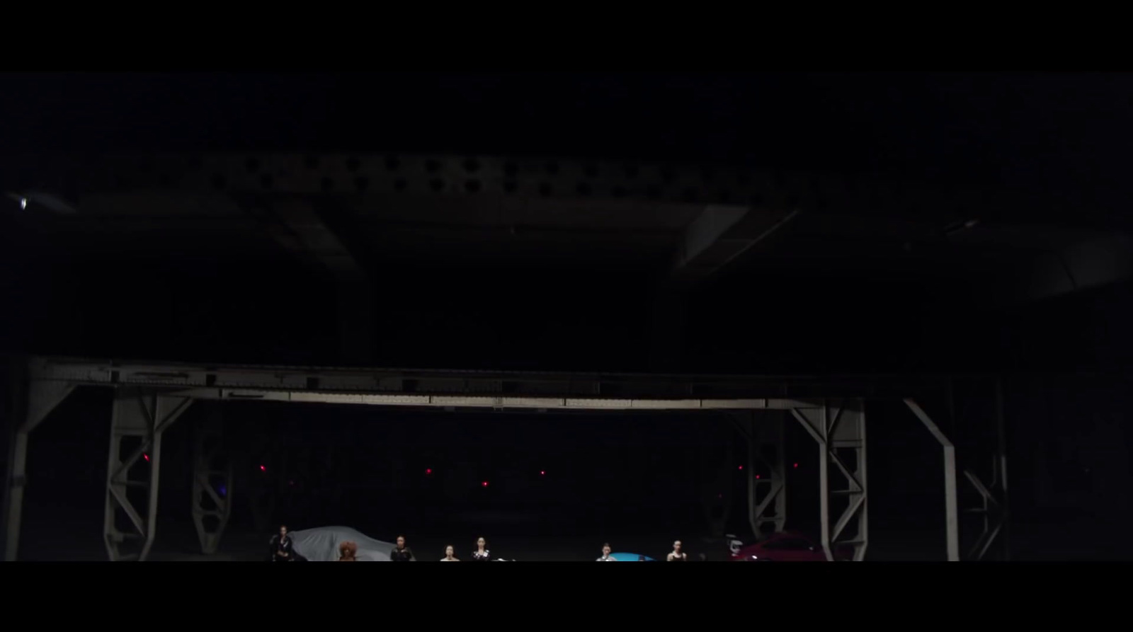 a group of people standing under a bridge at night