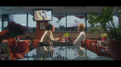 two women sitting at a table talking to each other