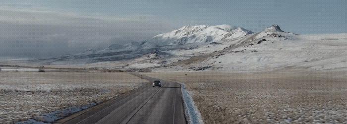 a truck is driving down a snowy road