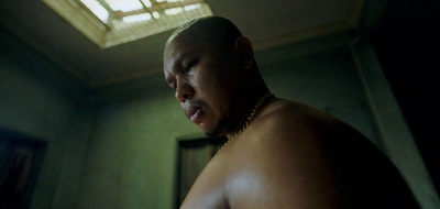 a shirtless man wearing a chain around his neck