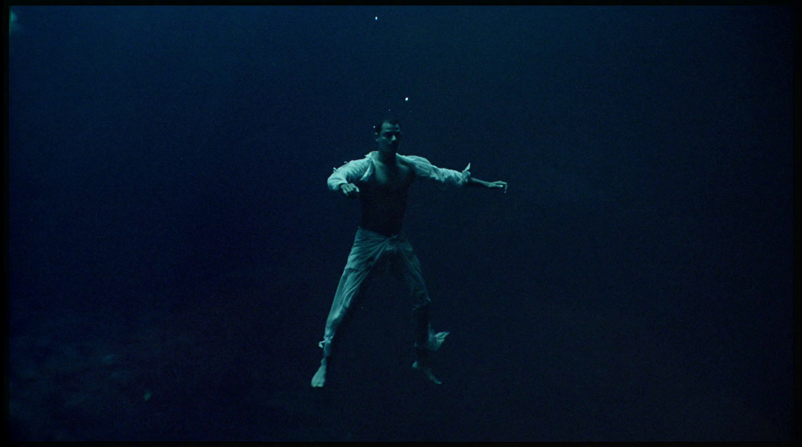 a man standing in the water with his arms outstretched