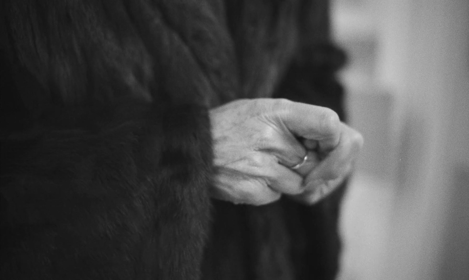 a woman's hand is holding onto a fur coat