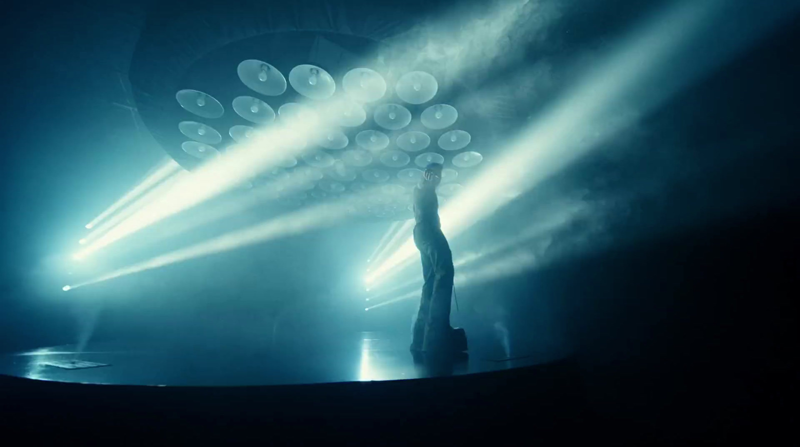 a person standing in front of a stage with lights