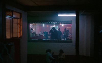 a group of people standing outside of a building at night