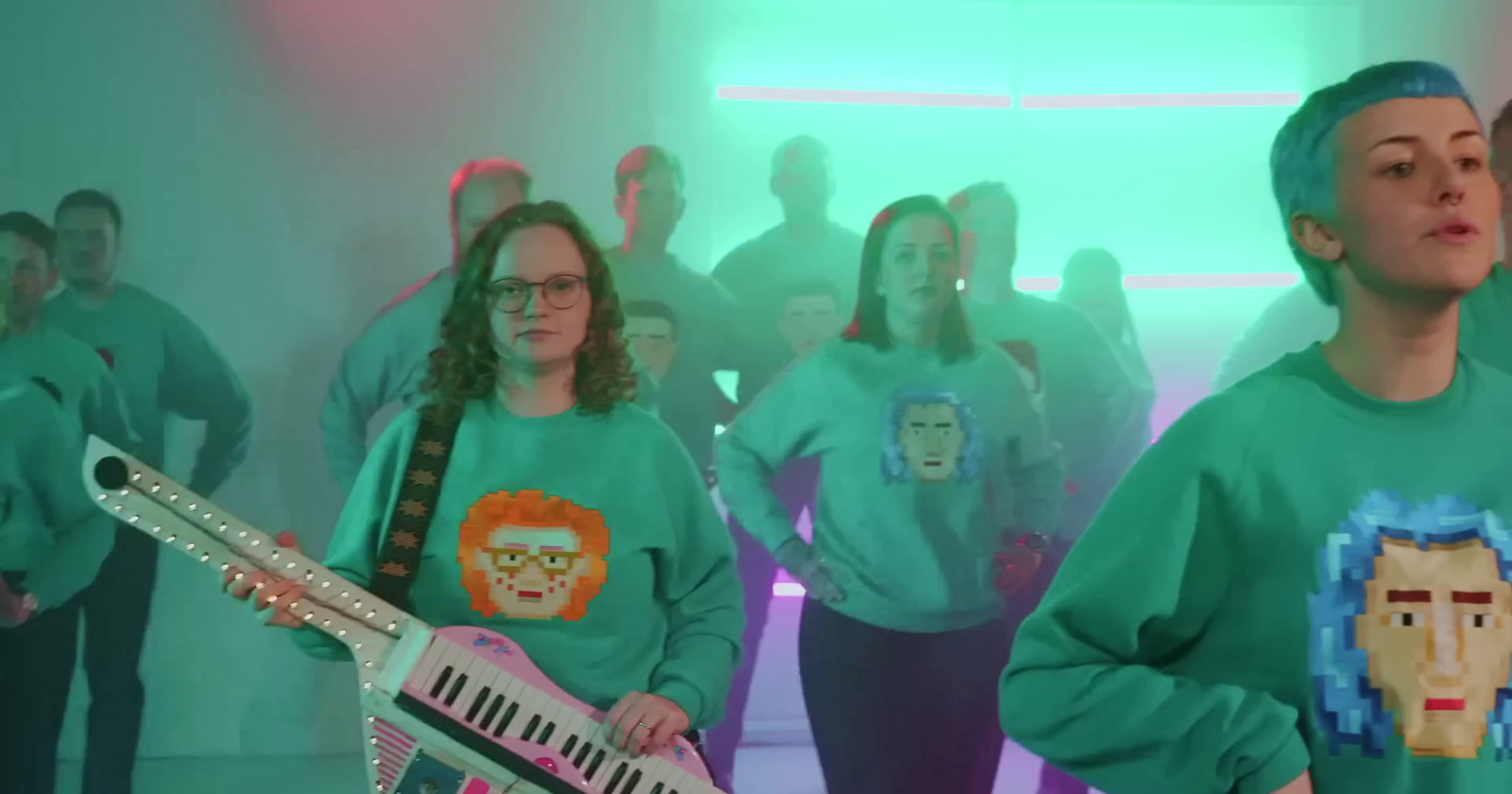 a group of people wearing green shirts and holding musical instruments