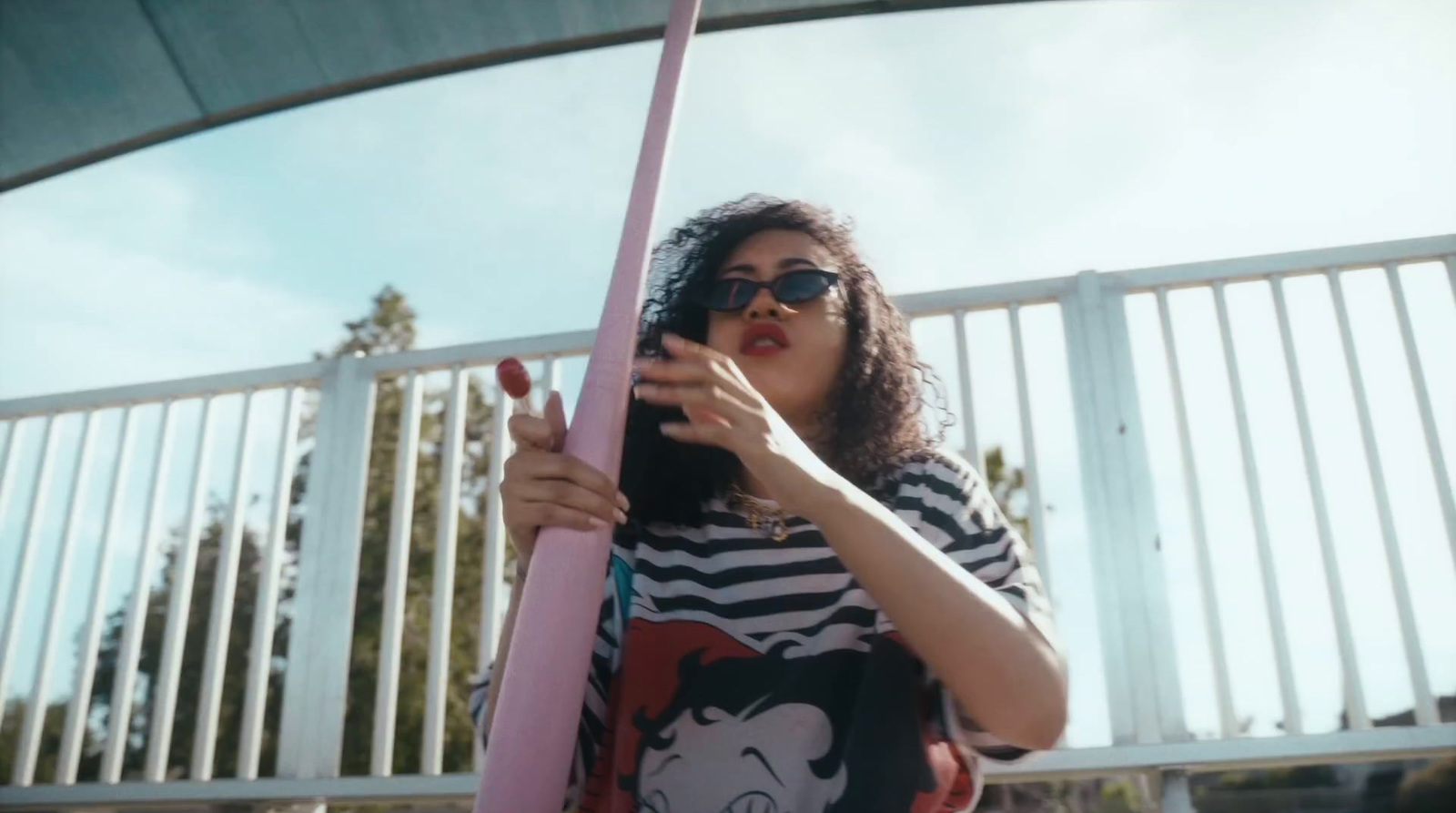 a woman in a striped shirt holding a pink pole