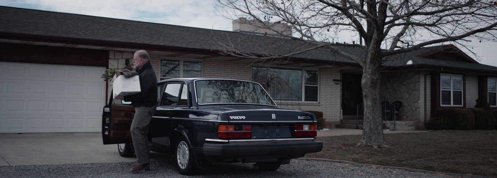 a man standing next to a car in front of a house