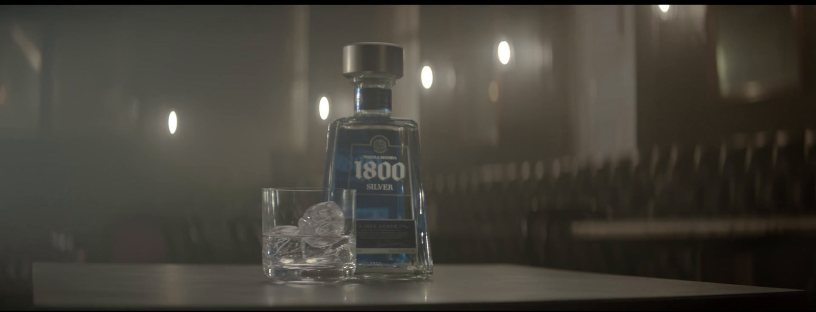 a bottle of alcohol sitting on a table next to a glass