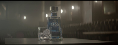 a bottle of alcohol sitting on a table next to a glass