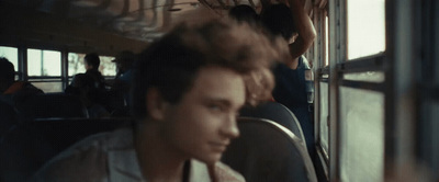 a man sitting on a bus looking at his cell phone